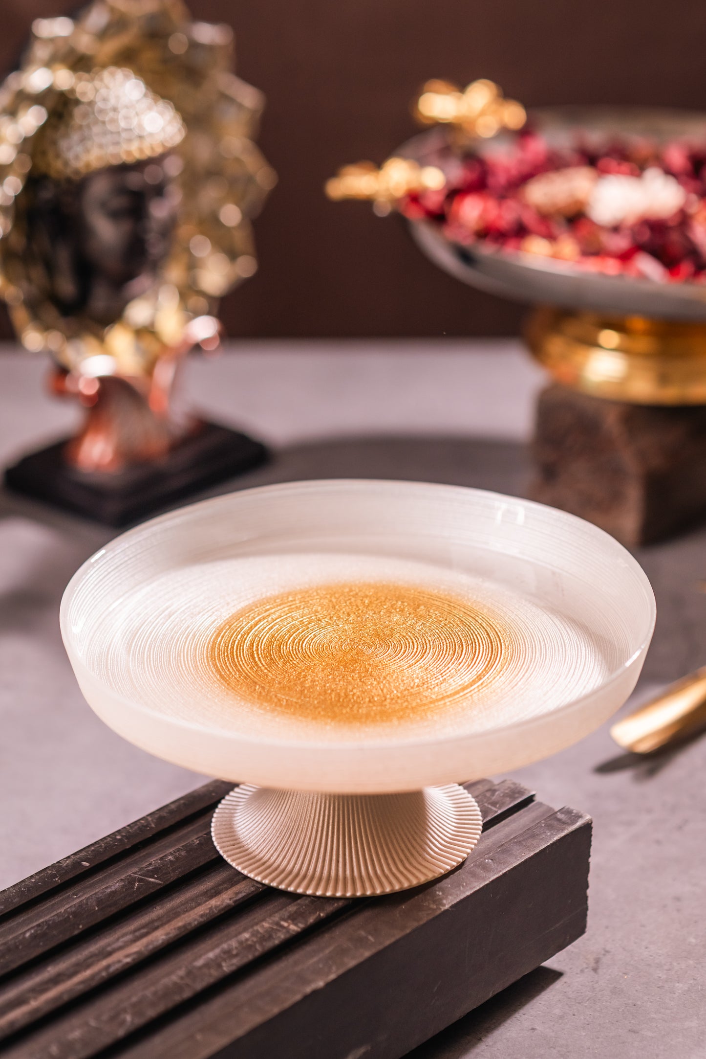 Decorative bowl with intricate design on a wooden stand against a blurred background