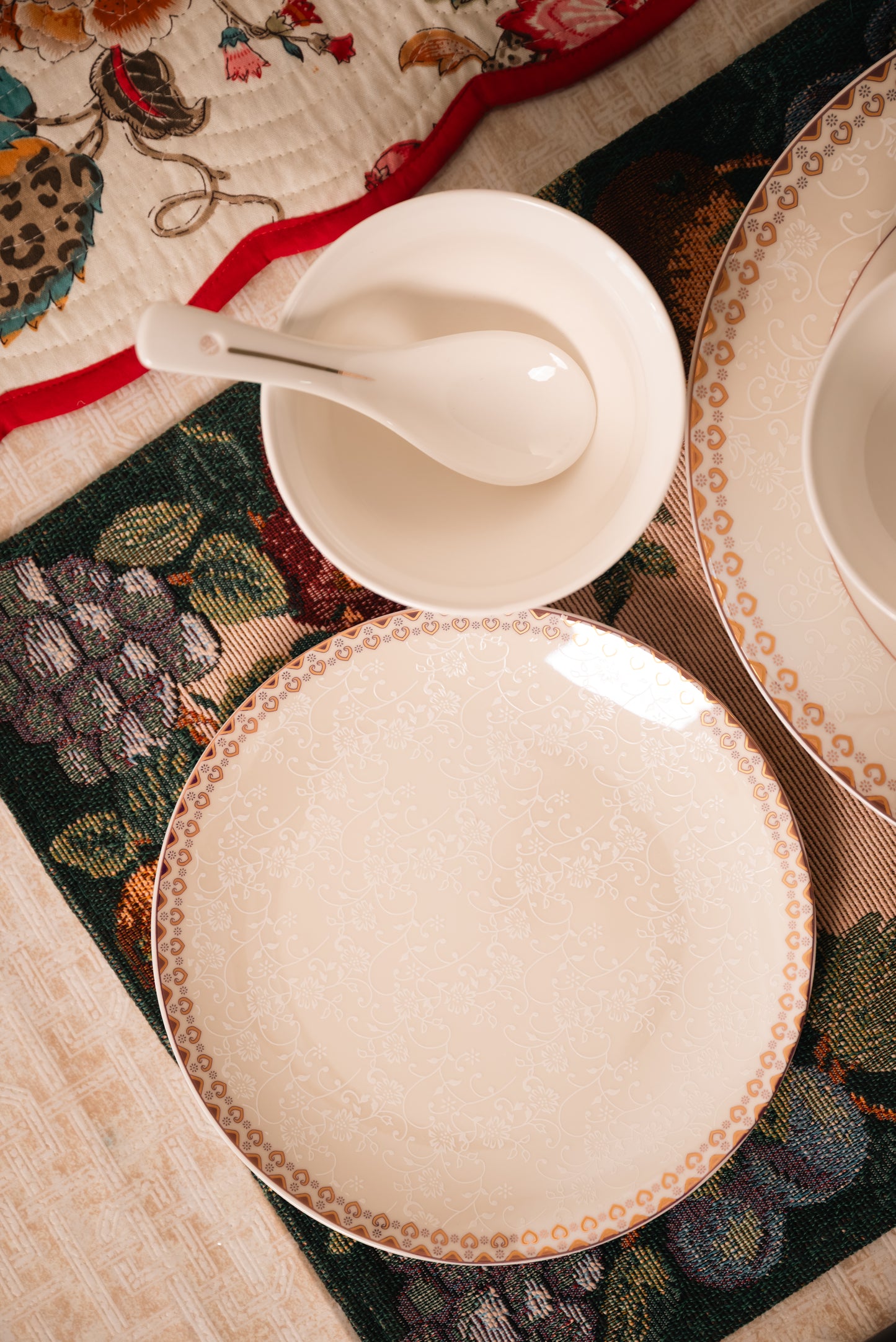 Set of ceramic plates and bowls on a decorative tablecloth
