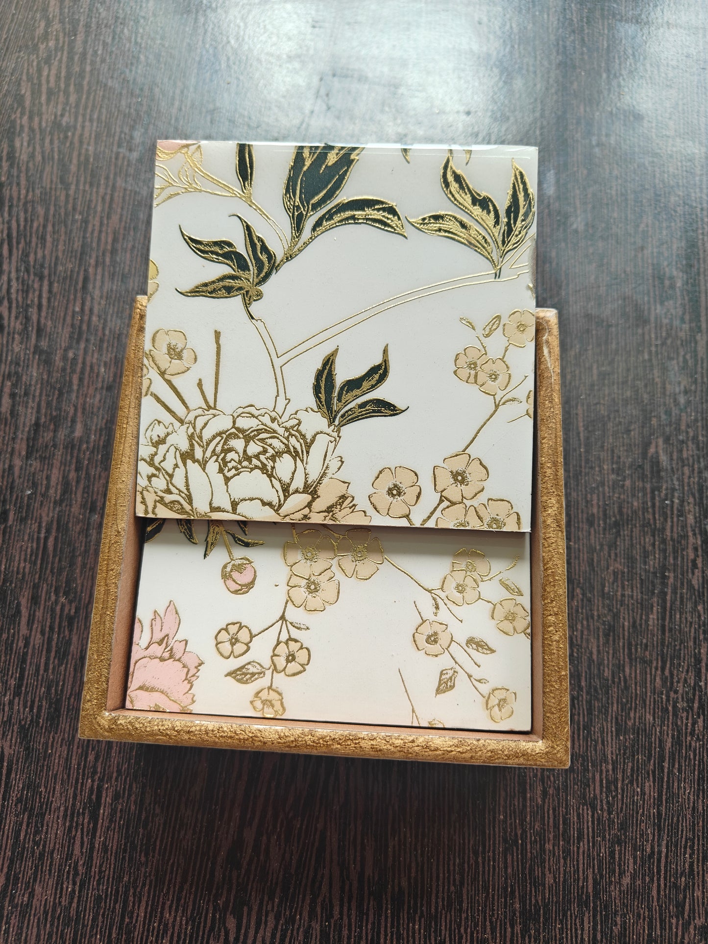 Floral design on Wooden Coasters against a dark wooden surface